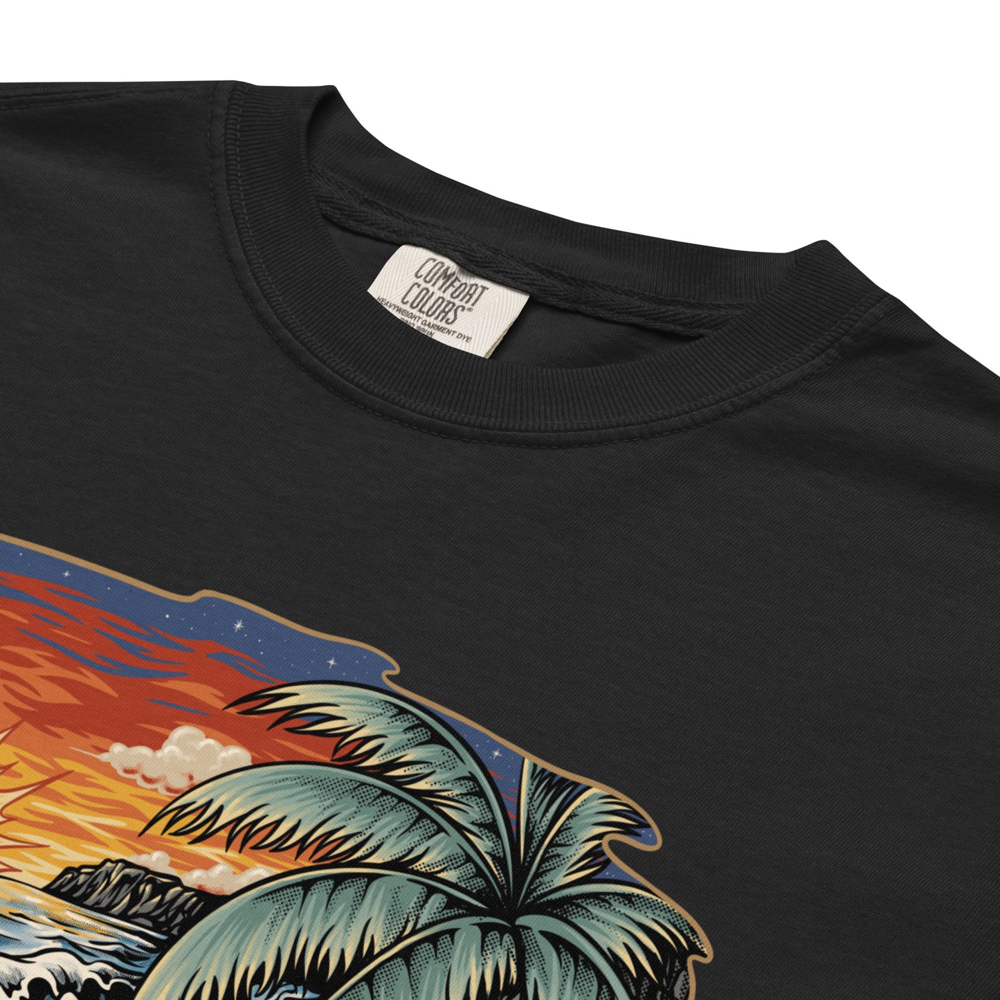 Close up of a black T‑shirt displaying Frosty the Sandman reclining on a tropical beach, complete with a palm tree, starfish, a beach ball, and an orange sunset.