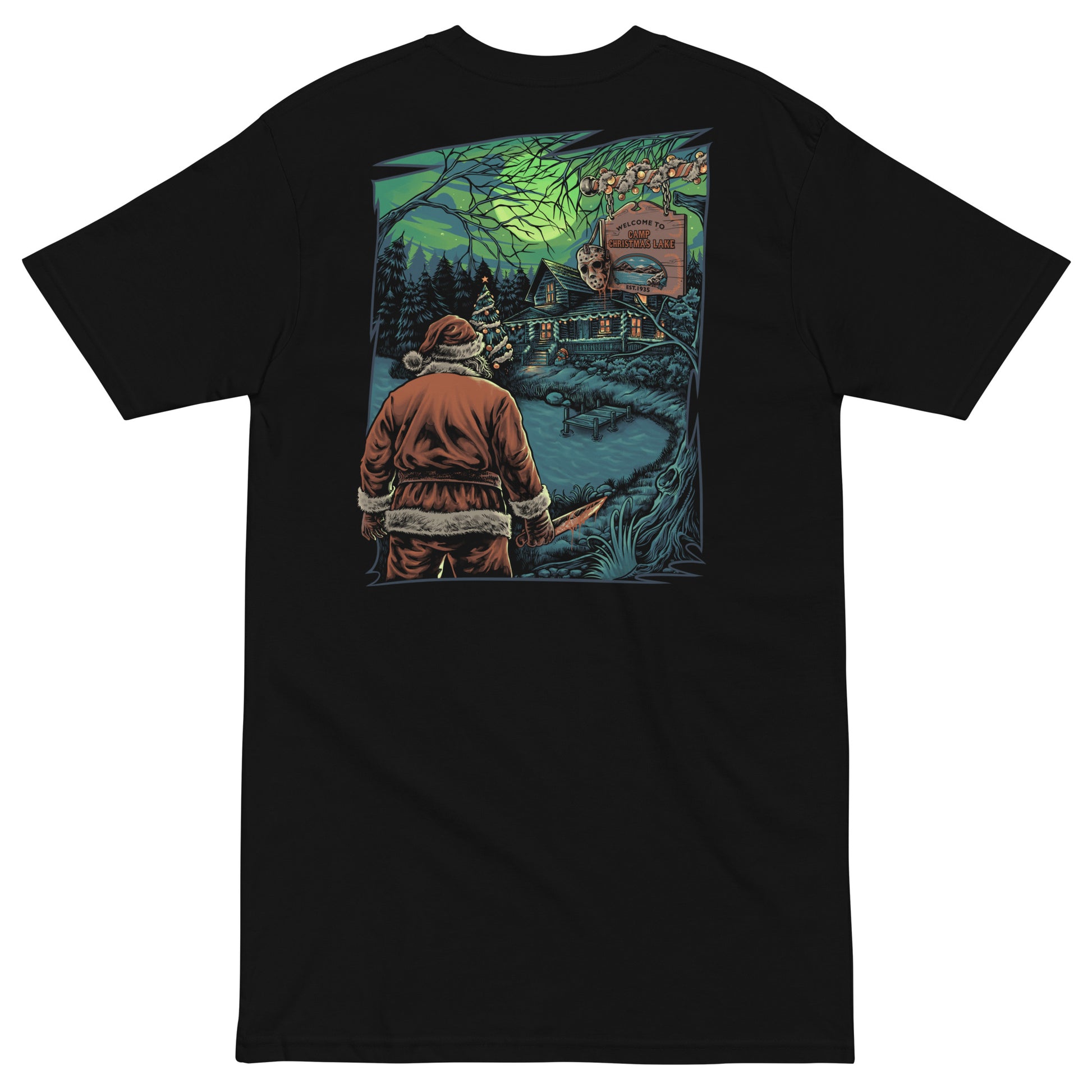 The image shows a black t-shirt with a unique holiday horror print. Santa Claus, axe in hand, stands by a cabin at "Camp Christmas Lake." The scene is illuminated by a full moon with an eerie green glow, reminiscent of classic horror films. This design cleverly merges Christmas iconography with the slasher genre.