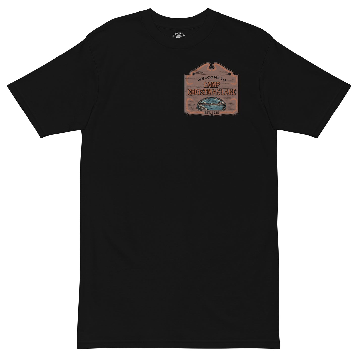 Product mockup featuring a black t-shirt with a wooden sign on the chest that says "Welcome to Camp Christmas Lake"