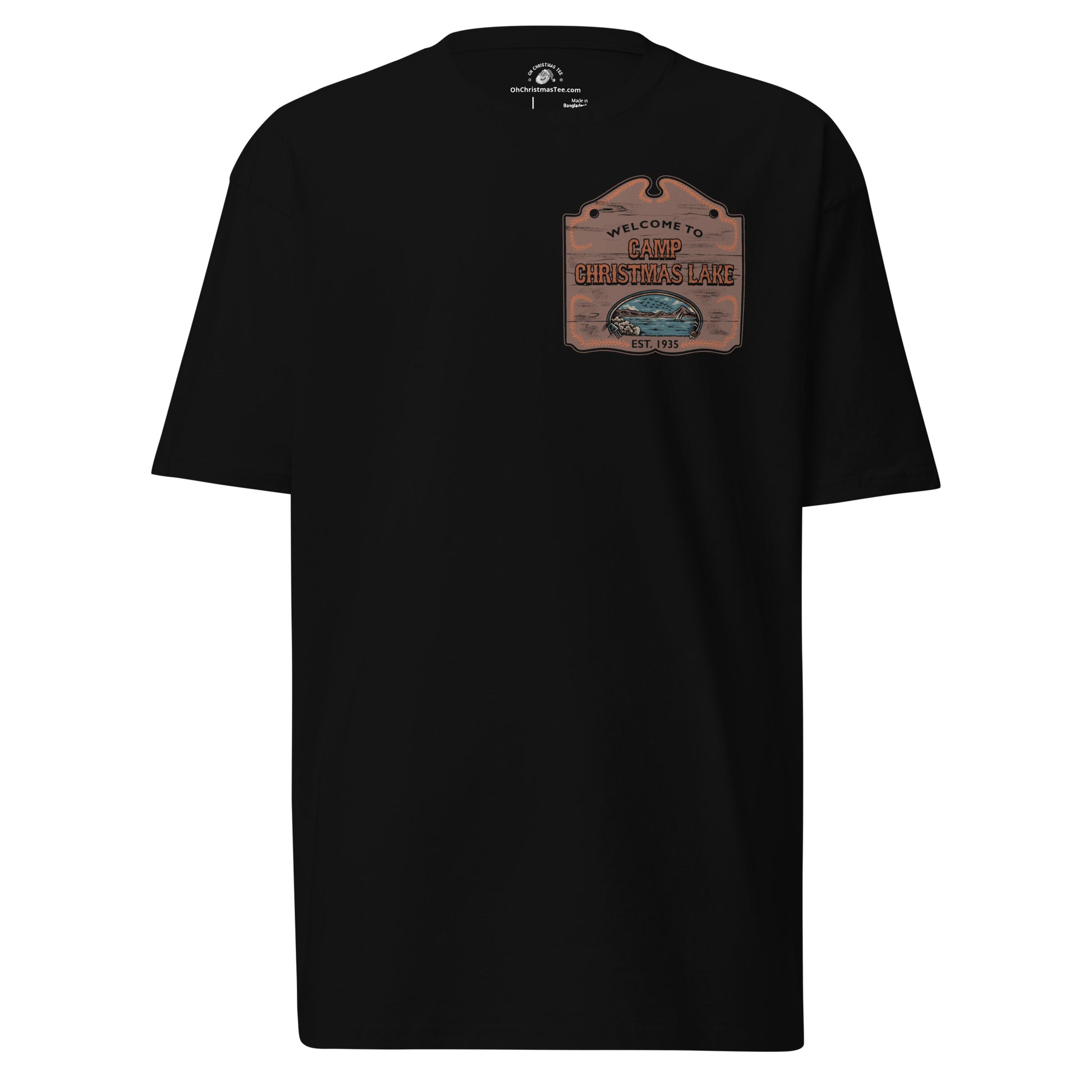 Product mockup featuring a black t-shirt with a wooden sign on the chest that says "Welcome to Camp Christmas Lake"