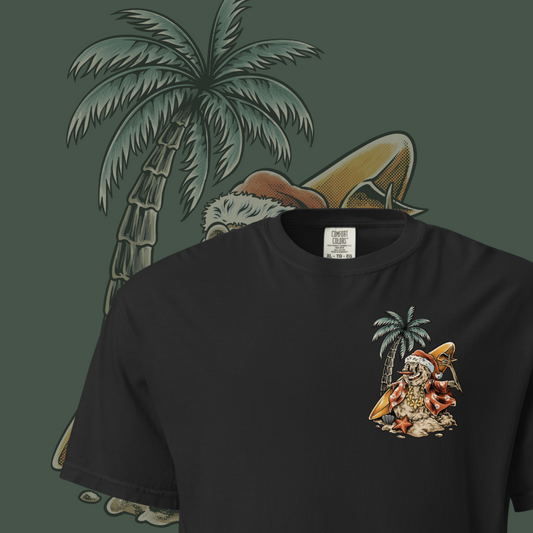 A black t-shirt with a graphic print of a snowman, palm trees, and beach elements, positioned in front of a stylized depiction of a palm tree.