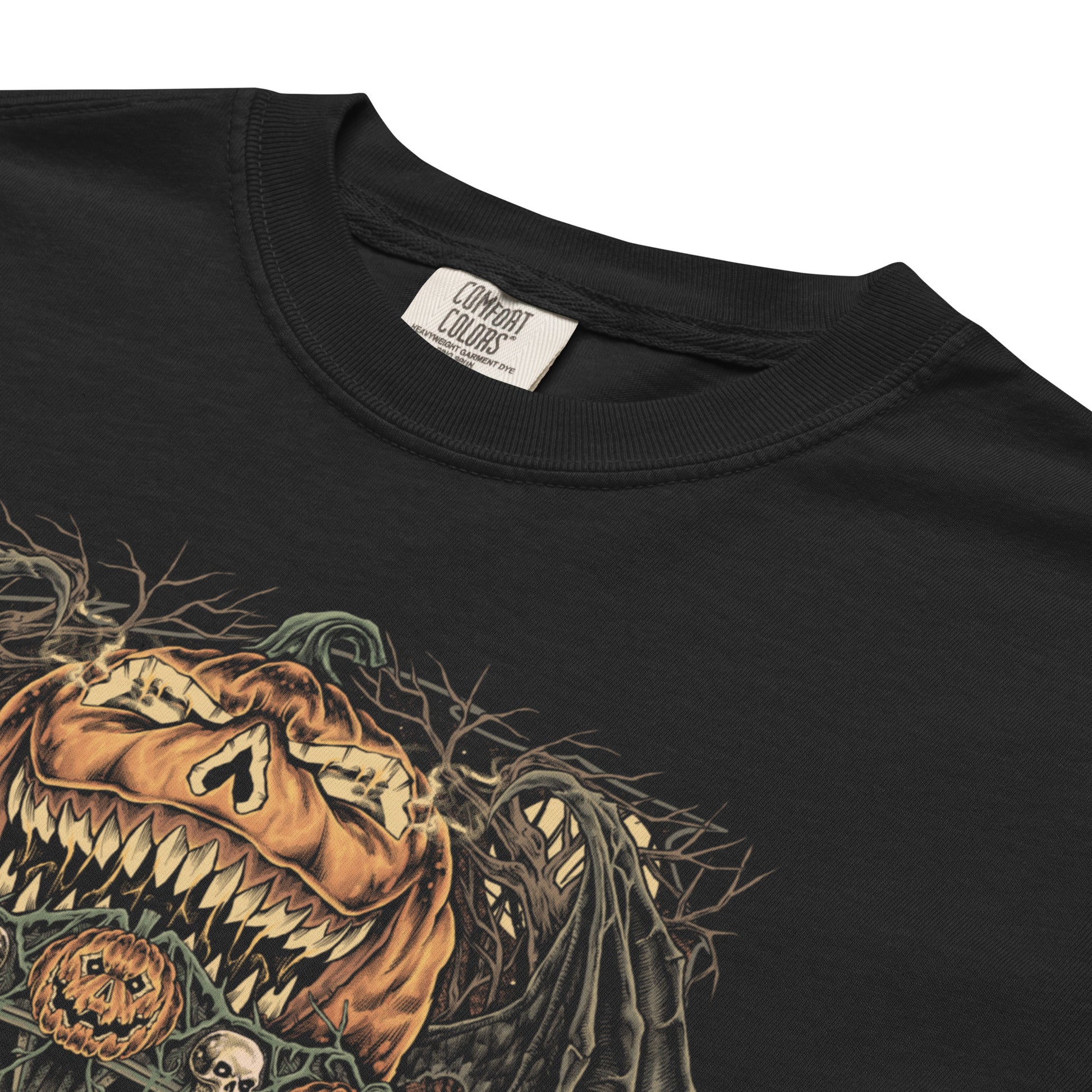 Black halloween T‑shirt featuring a haunted carnival carousel made of jack‑o’‑lanterns with skeletal horses, skulls, bats, and a gravestone under a giant grinning pumpkin head.